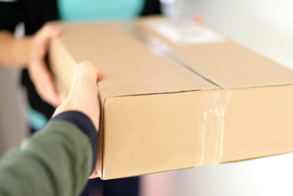 Homeowner accepting a package from a delivery person.